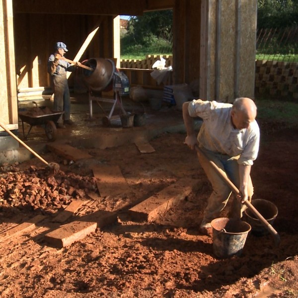 Pour améliorer l’inertie du bâtiment, certaines cloisons seront en terre. On voit ici la récupération de la terre argileuse sur le chantier